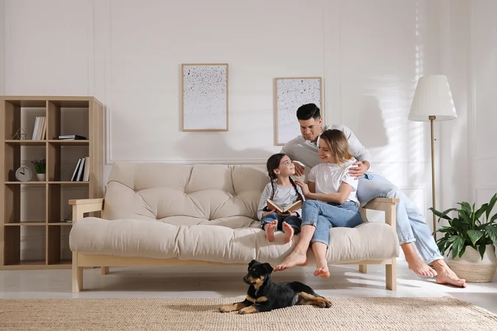 A happy family sits comfortably on a couch